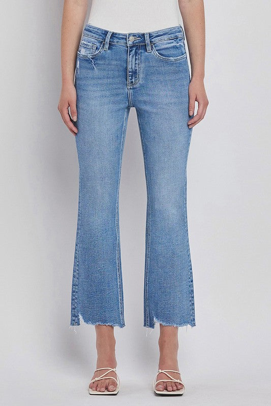 Mid/high rise uneven hem crop kick flare stretch jeans in medium wash with tummy control