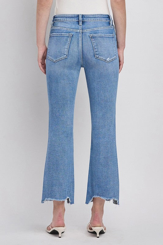 Mid/high rise uneven hem crop kick flare stretch jeans in medium wash with tummy control