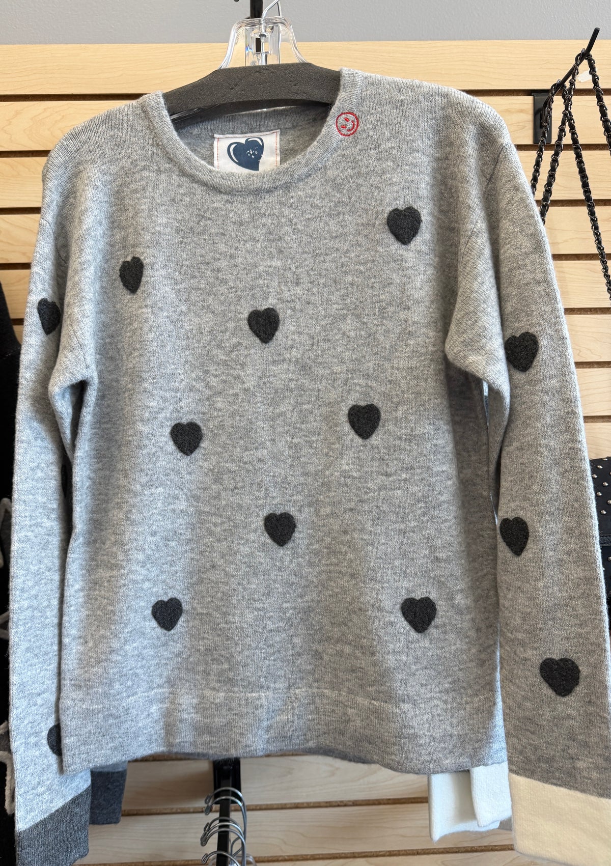 Grey soft knit sweater with scattered hearts and colorblock cuffs