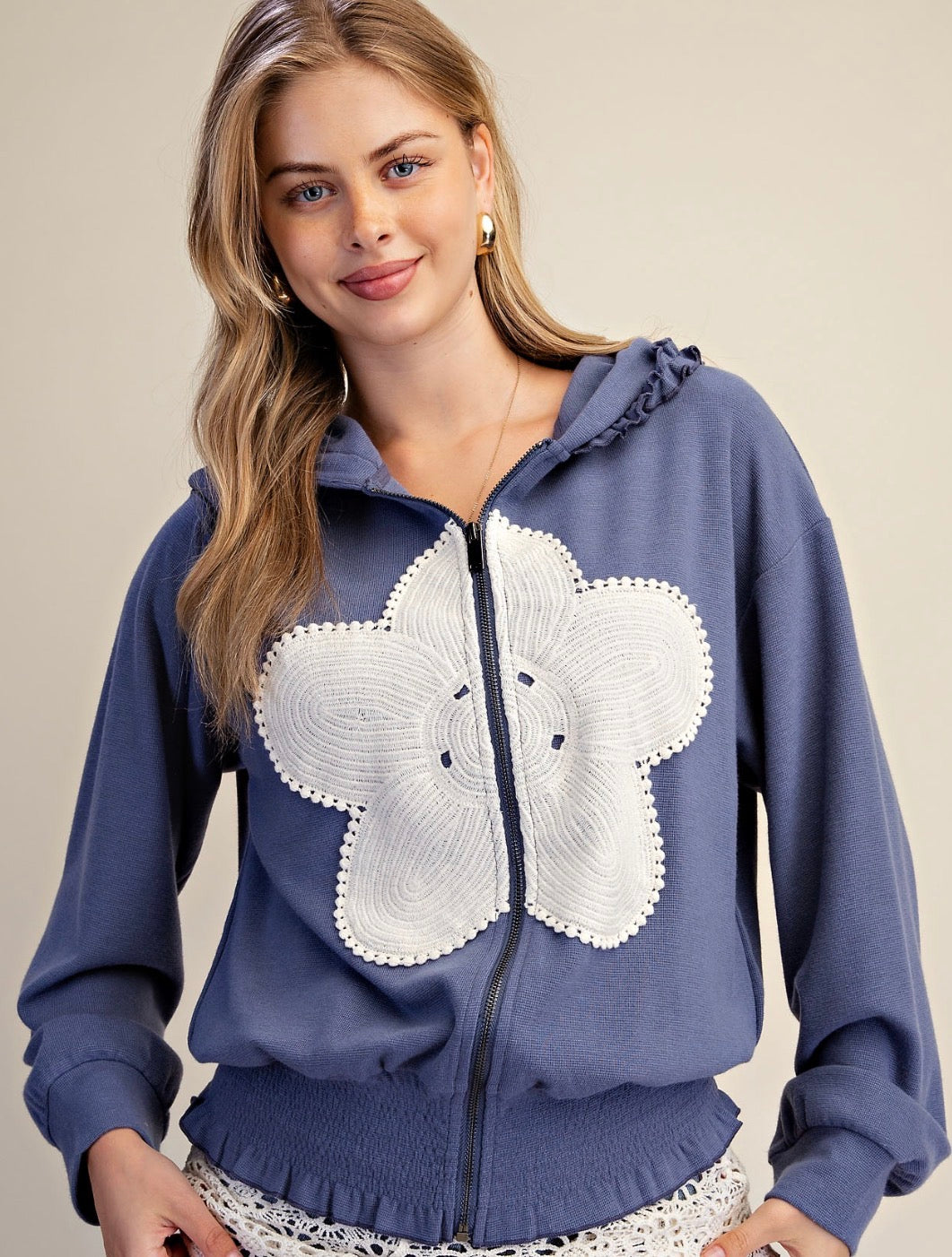 Blue zip hoodie with white flower patch and ruffle detail