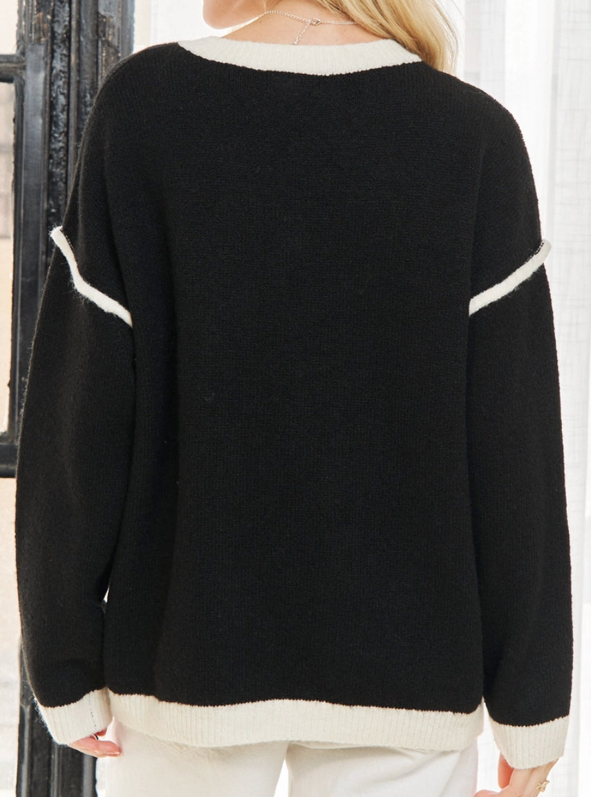 Black v neck sweater with white daisies