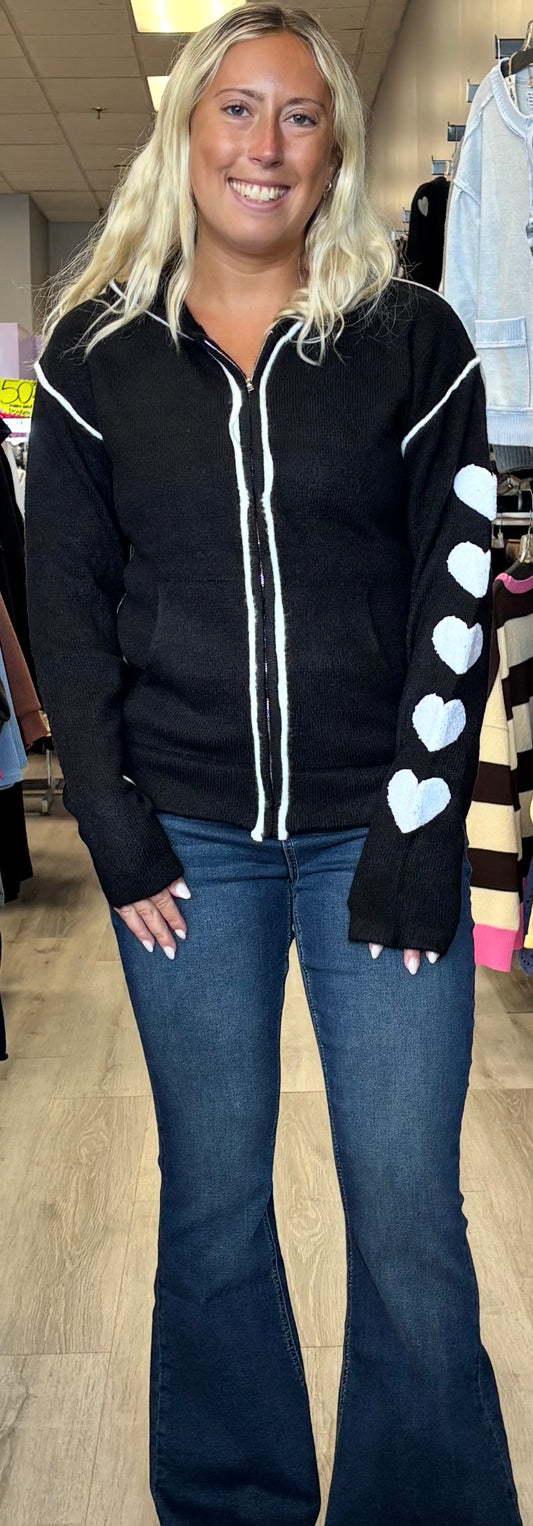 Black soft knit zip up with white hearts on one sleeve